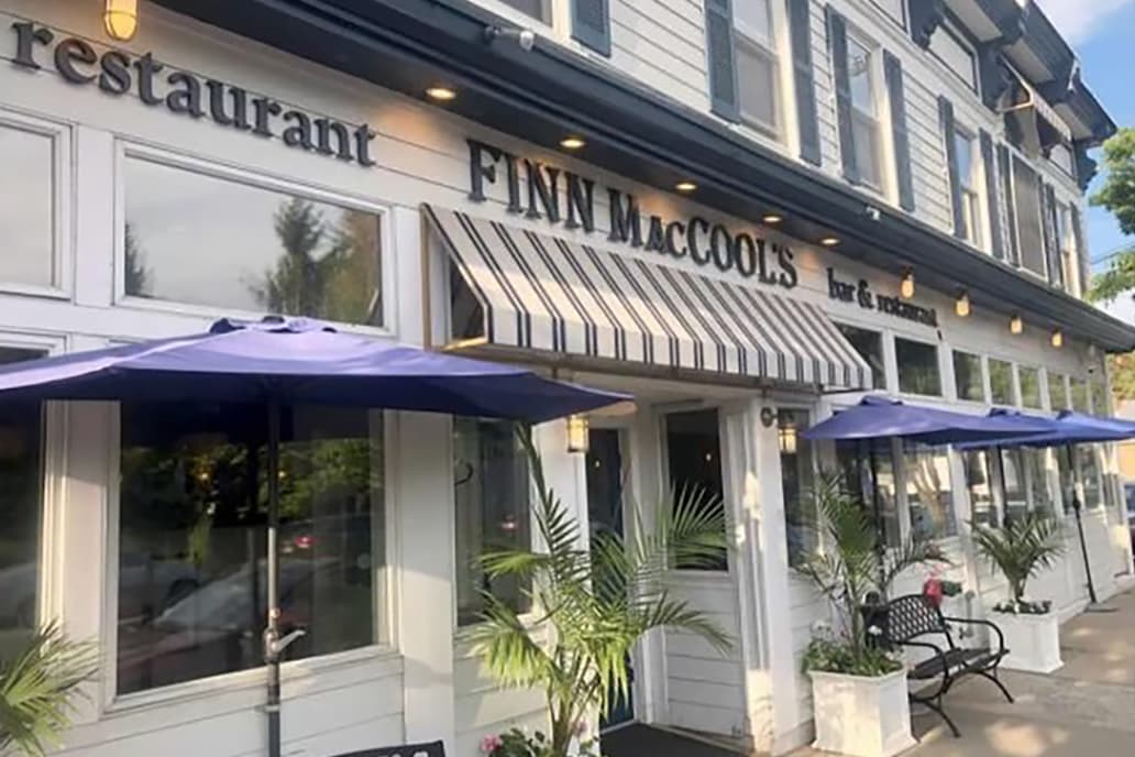 Man in blue tshirt and red hat piloting a water taxi