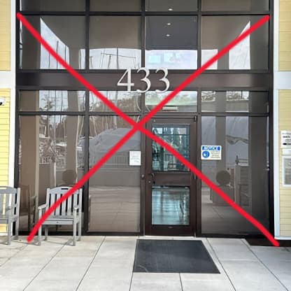 A building with glass doors and the number 433 on the door with a red X on the photo